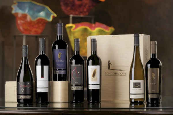 This image features an assortment of seven wine bottles displayed in front of a box labeled 