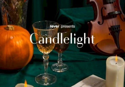 The image features candles, a pumpkin, wine glasses, sheet music, and a violin, with text 