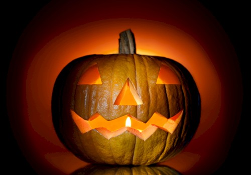 This image shows a carved jack-o'-lantern with a lit candle inside, creating an eerie glow against a dark background always ending the sentence.